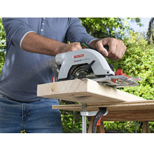 O persoană taie o scândură de lemn cu un fierăstrău circular portabil Bosch.