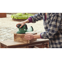 O persoană șlefuiește o bucată de lemn cu o șlefuitoare excentrică fără fir Bosch.