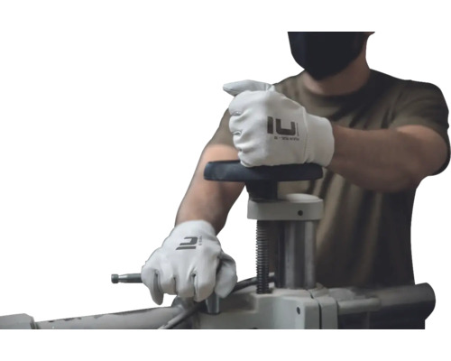 O persoană cu mănuși operează un banc de lucru.