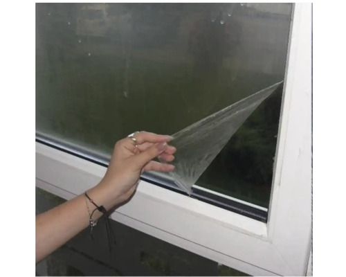 Fereastră cu o persoană care îndepărtează o folie de protecție.