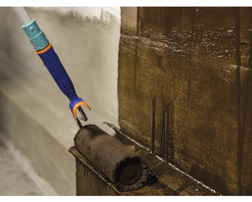 Aplicarea unui strat cu o rolă de vopsea pe un perete