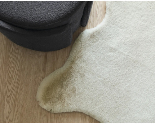 Imitație decorativă de piele de animal lângă un taburet gri pe o podea de lemn.