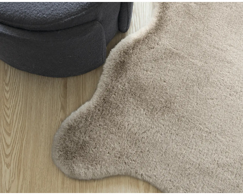 Imagine detaliată a unui covor și a unei piese de mobilier pentru șezut pe podea de lemn