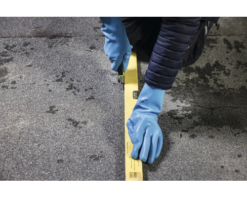 O persoană cu mănuși taie cu un cuțit de-a lungul unui boloboc pe o suprafață.