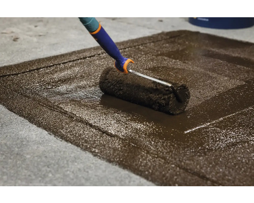 Aplicarea grundului pe o podea de beton cu o rolă de vopsea