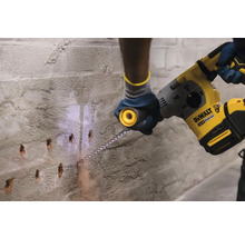 Artizan care găurește un perete cu un ciocan rotopercutor.