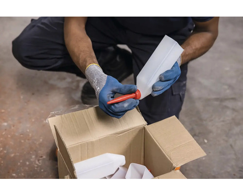 O persoană atașează un gât de scurgere roșu unei sticle albe deasupra unei cutii de carton.