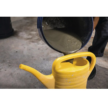 Beton este turnat într-o stropitoare galbenă.