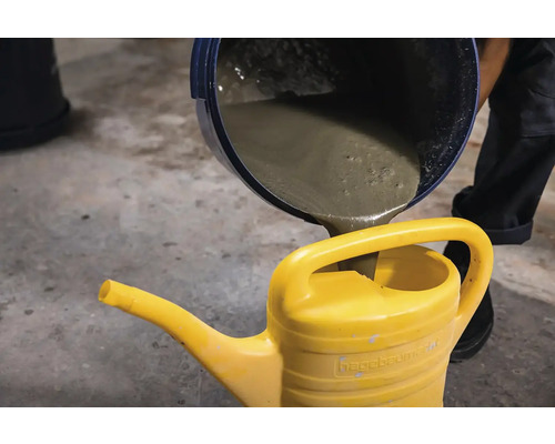 Beton este turnat într-o stropitoare galbenă.