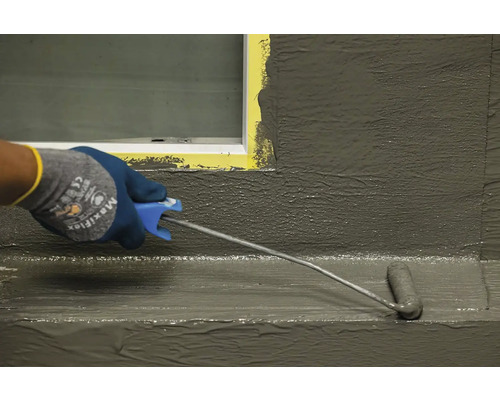 Aplicarea unui etanșant cu o rolă de vopsea pe o suprafață.