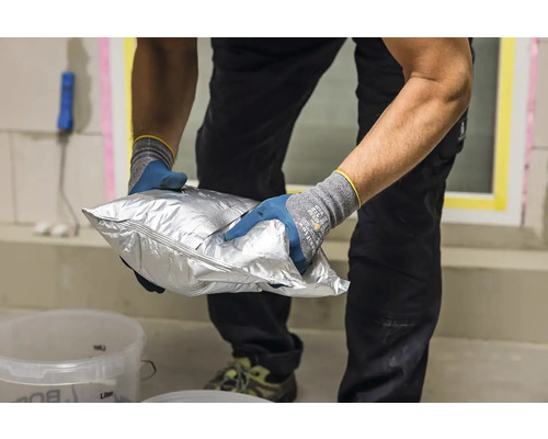 O persoană ține în mâini un pachet argintiu de chit.