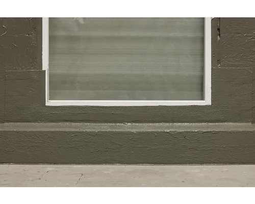 Detaliu fereastră cu ramă într-un perete tencuit