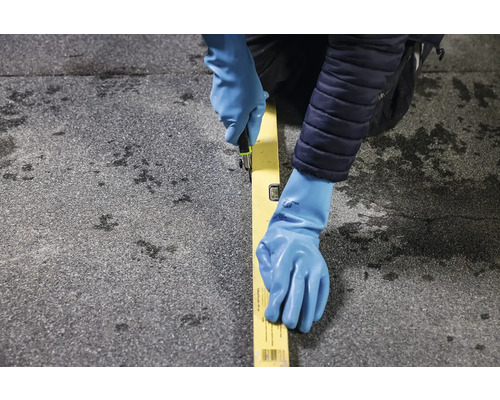 O persoană taie cu un cutter de-a lungul unui boloboc pe o suprafață de acoperiș.