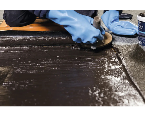 Aplicarea adezivului bituminos pe o suprafață cu o pensulă