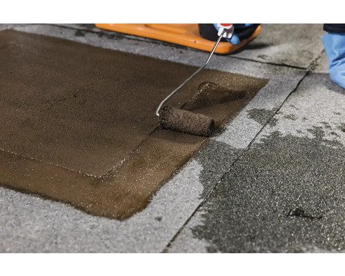 Aplicarea unui strat de acoperire pe acoperiș cu o rolă de vopsea pe o suprafață de acoperiș