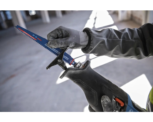 O persoană introduce o lamă de ferăstrău electric într-un ferăstrău electric.