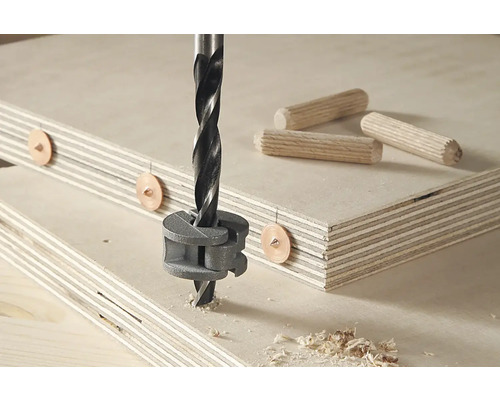 Burghiu pentru lemn care găurește o scândură cu dibluri și șablon pentru dibluri