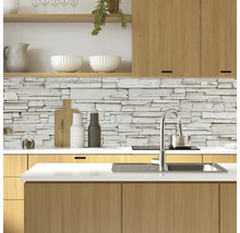 Bucătărie modernă cu perete de piatră, chiuvetă și elemente din lemn.