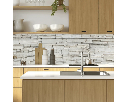 Bucătărie modernă cu perete de piatră, chiuvetă și elemente din lemn.