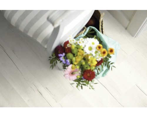 Vedere a unei podele din lemn deschisă la culoare cu un buchet de flori