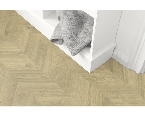 Pardoseală din lemn deschis la culoare în model herringbone lângă un raft alb cu o pătură