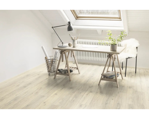 Cameră luminoasă cu podea laminată, birou pe capre și fereastră de mansardă pentru o atmosferă prietenoasă.