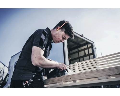 Artizan care rindeluiește lemn cu rindel electric în exterior