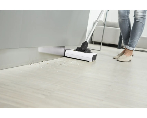 Persoană aspiră podeaua cu un aspirator