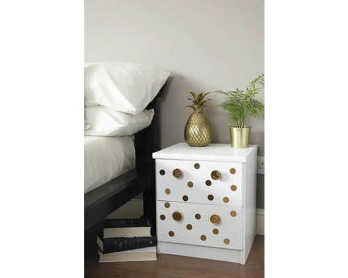 Dormitor decorativ cu noptieră albă, împodobită cu cercuri și accente aurii