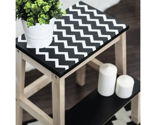 Taburet din lemn cu model în zigzag, plantă și lumânări