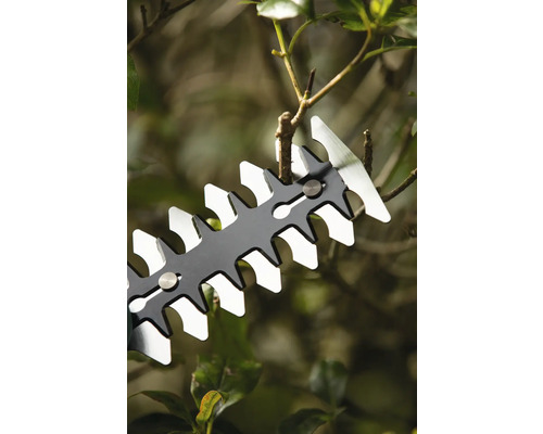 Prim-plan cu o foarfecă de gard viu tăind ramuri