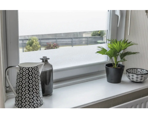 Folie decorativă pe o fereastră cu un ceainic de cafea, o sticlă, o plantă la ghiveci și un bol pe o pervază