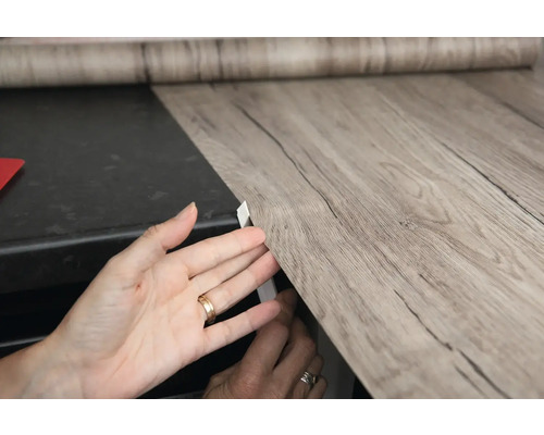 Aplicarea unei folii autoadezive cu aspect de lemn pe o suprafață