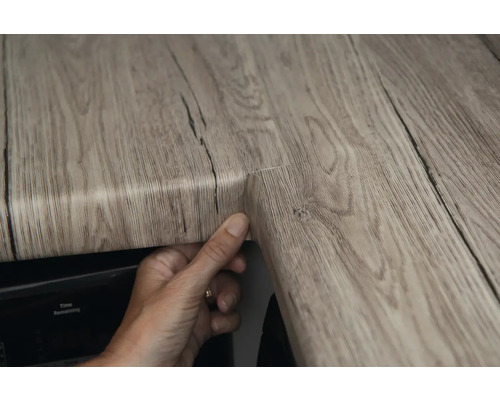 Îmbinare în colț a unui blat cu aspect de lemn.