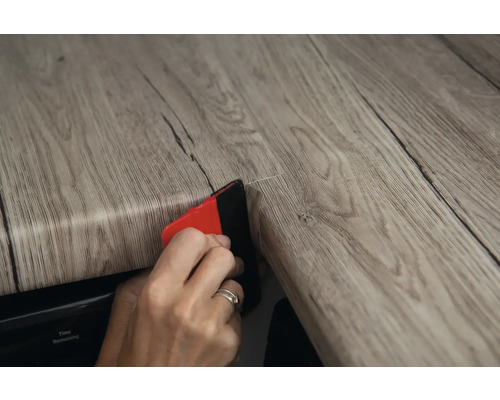 Aplicarea unei folii decorative cu racletă pe o suprafață de lemn