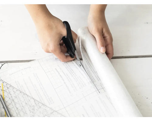 Tăierea unei folii transparente cu o foarfecă