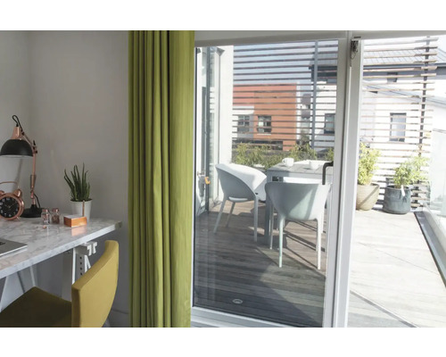 Cameră luminoasă cu birou, scaun și perdea, vedere la o terasă cu masă și scaune