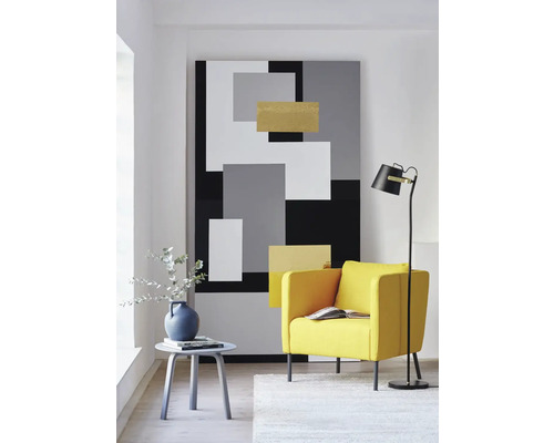 Cameră de zi cu fotoliu, lampă de podea, măsuță laterală și pictură murală abstractă cu design geometric.