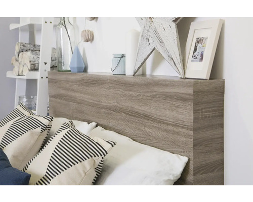 Pat cu tăblie în aspect de lemn și raft de depozitare cu obiecte decorative și perne