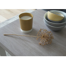 Aranjament decorativ cu lumânare, ceapă ornamentală și boluri pe o masă