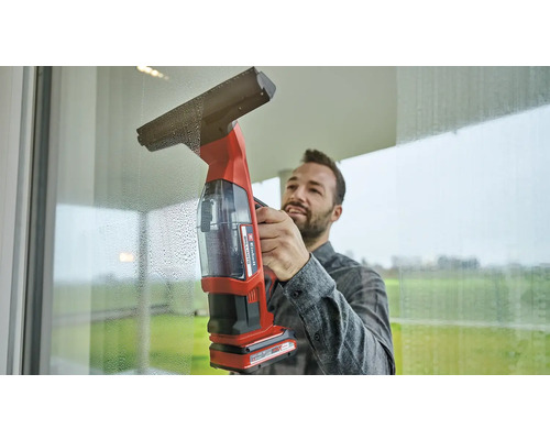Bărbat care curăță ferestre cu un aspirator de geamuri fără fir