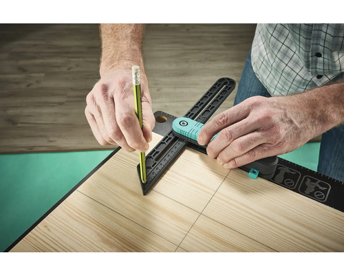 O persoană folosește un raportor și un creion pentru a trasa linii pe o scândură de lemn.