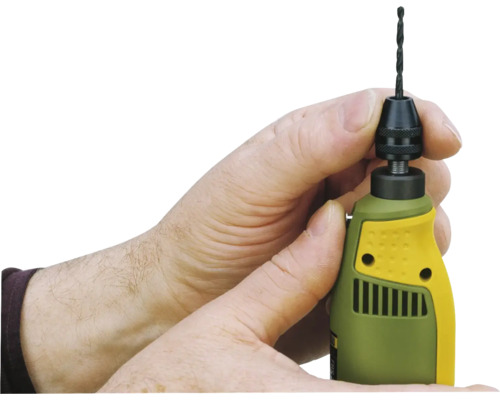 O persoană schimbă un burghiu la o mașină de găurit.