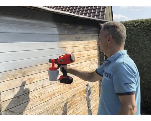 Bărbat care vopsește un perete de lemn cu un sistem de pulverizare a vopselei