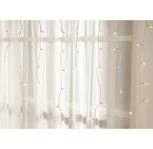 Cortină luminoasă cu LED-uri albe calde în fața ferestrei