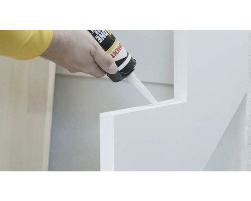 O persoană aplică etanșant pe o scară.