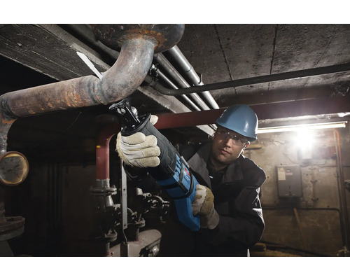 Meșter care taie o țeavă cu un fierăstrău coadă de vulpe