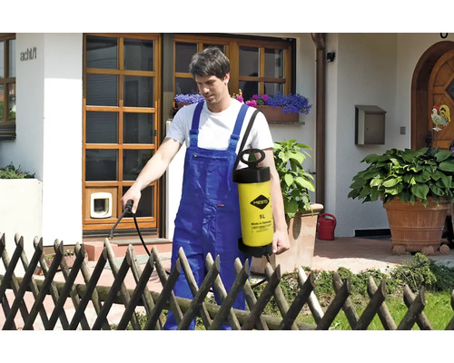 Bărbat folosind un pulverizator de grădină Mesto pentru grădinărit în fața unei case.