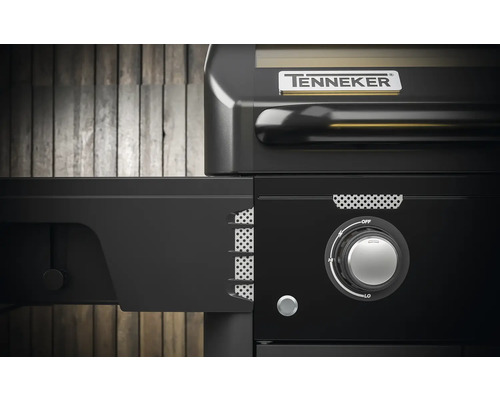 Detaliu al unui grătar pe gaz Tenneker cu masă laterală și buton rotativ pentru controlul căldurii.