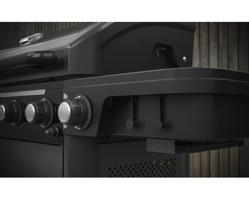 Prim-plan cu un grătar pe gaz negru cu butoane rotative pentru reglarea căldurii